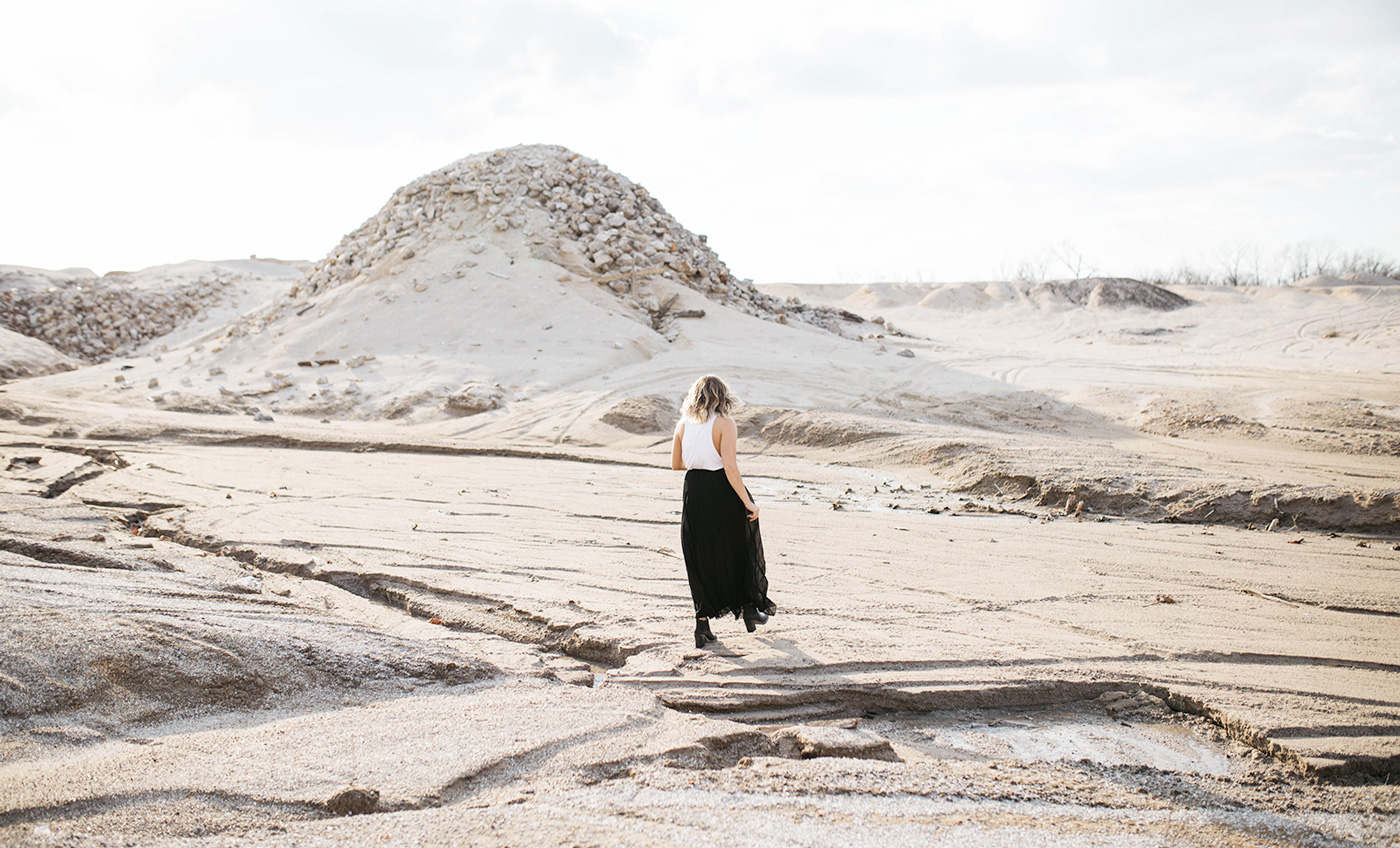 A woman walking on sandy stone