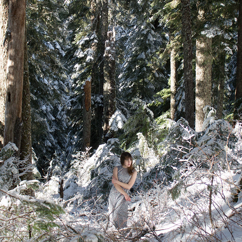 A woman standing in a snowy forest