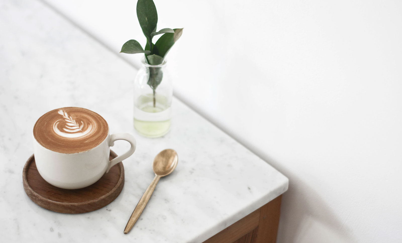 A coffee with latte art at a corner of a countertop