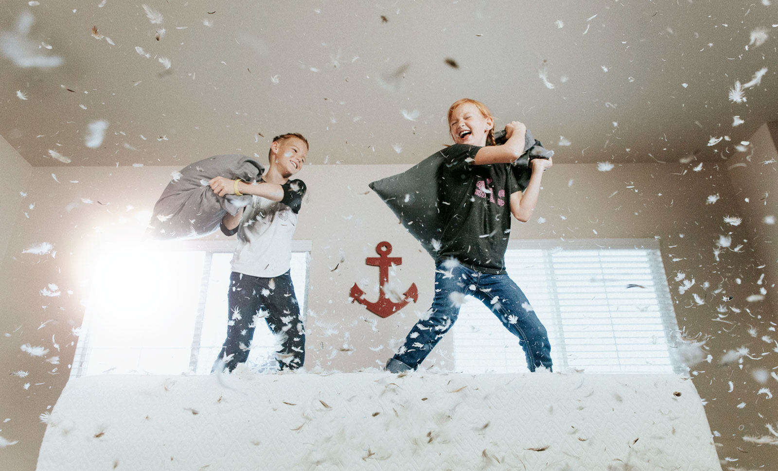 Two kids having a pillow fight