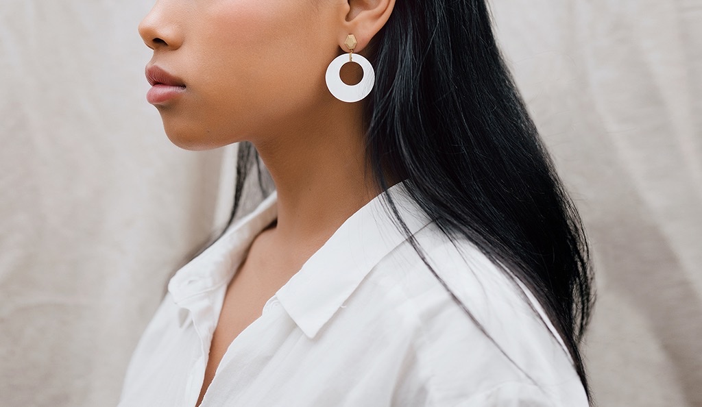 A woman with white round earrings