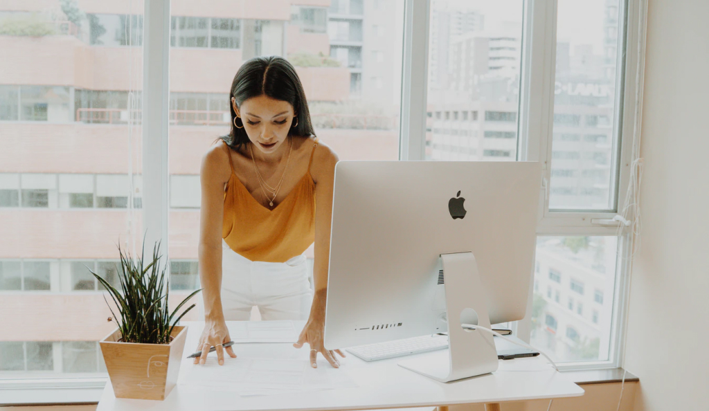 A woman in front of an apple desktop