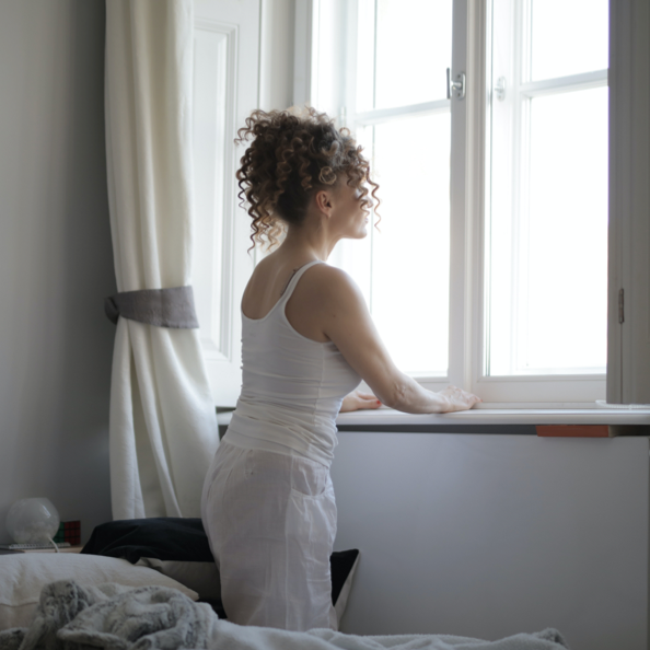 A woman with curly hair looking out the window